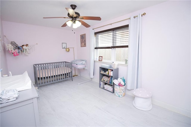 bedroom featuring a crib and ceiling fan