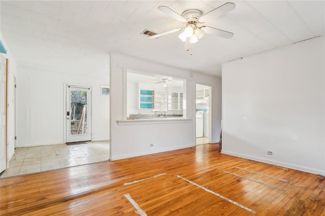 unfurnished living room with ceiling fan and light wood-type flooring