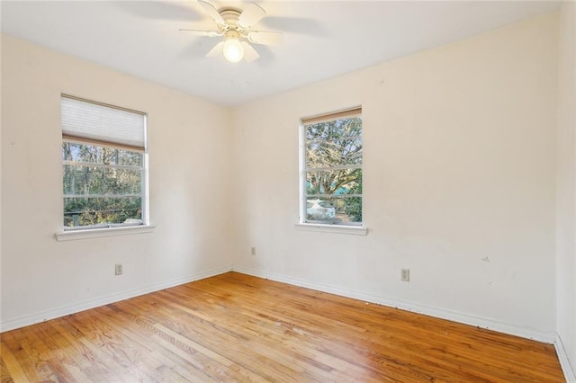 empty room featuring ceiling fan, a healthy amount of sunlight, and light hardwood / wood-style flooring