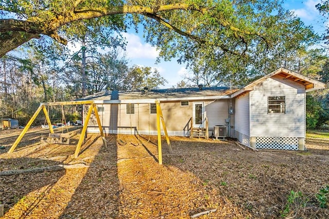 view of outdoor structure featuring a playground and central AC