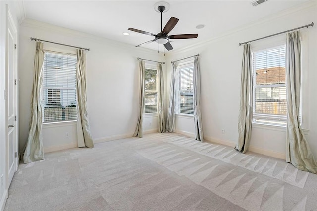 empty room with ceiling fan, light colored carpet, and ornamental molding