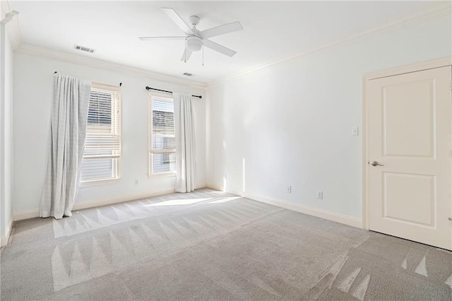 empty room featuring crown molding, ceiling fan, and light carpet