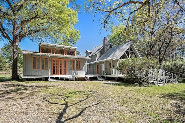 rear view of property with french doors, a deck, and a lawn