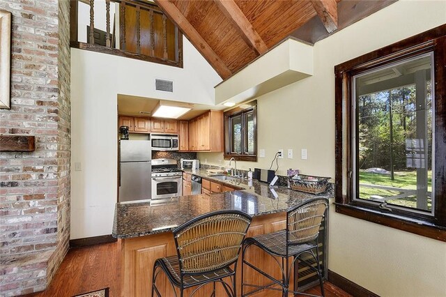 15082 Old Farms Rd, Folsom, LA 70437 - kitchen featuring appliances with stainless steel finishes, sink, a kitchen breakfast bar, dark stone counters, and kitchen peninsula