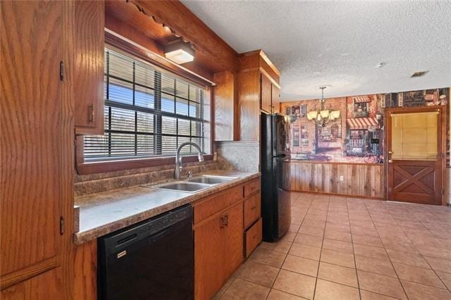 kitchen with pendant lighting, sink, black appliances, a textured ceiling, and light tile patterned flooring