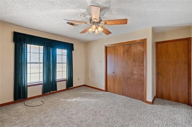 unfurnished bedroom featuring ceiling fan, carpet flooring, and a textured ceiling