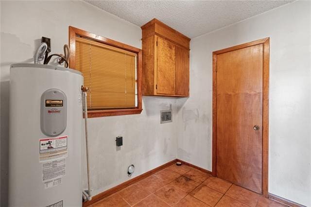 washroom with cabinets, a textured ceiling, light tile patterned floors, electric water heater, and washer hookup