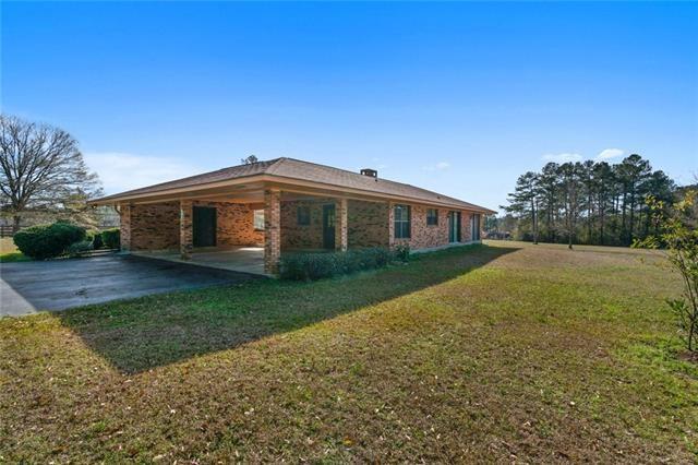 view of property exterior with a yard and a carport