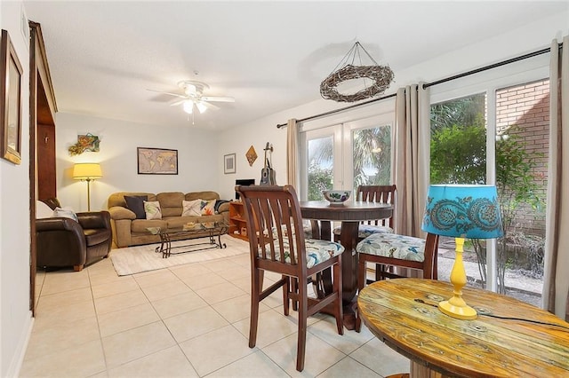 tiled dining space featuring ceiling fan and french doors