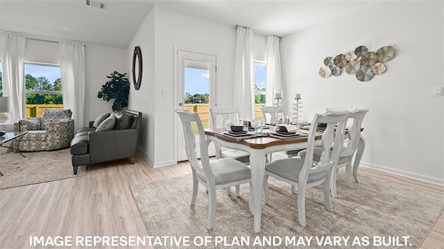 dining room featuring a healthy amount of sunlight and light hardwood / wood-style floors