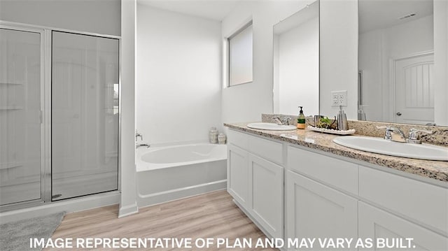 bathroom with vanity, hardwood / wood-style floors, and plus walk in shower