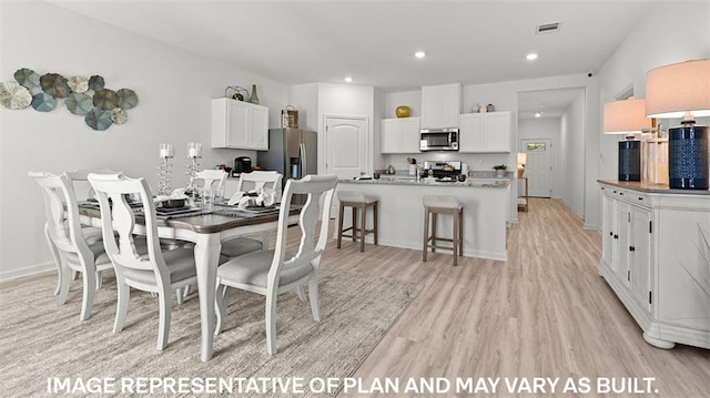 dining space with light hardwood / wood-style floors