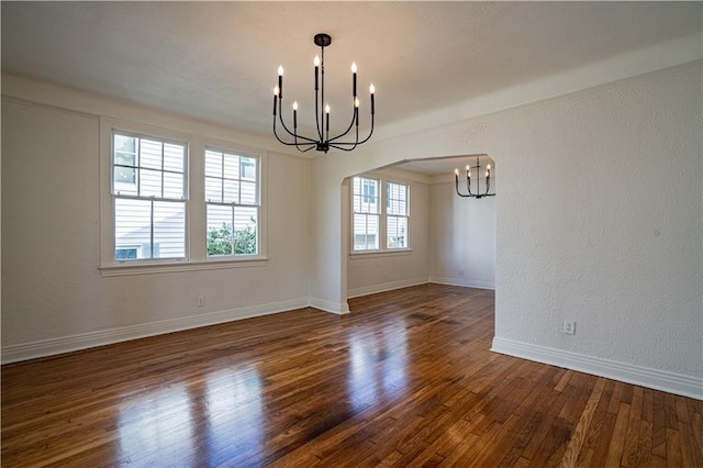 unfurnished dining area featuring dark wood-type flooring and a chandelier