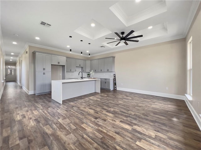 kitchen featuring pendant lighting, gray cabinetry, and a center island with sink