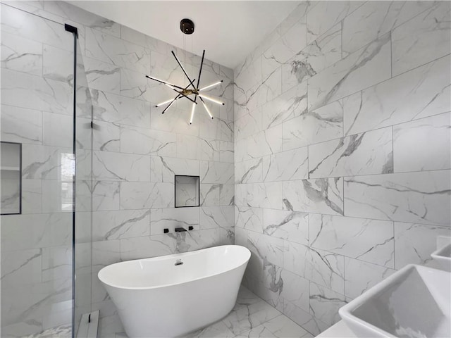 bathroom featuring a washtub and a chandelier