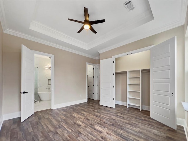 unfurnished bedroom featuring dark hardwood / wood-style floors, ornamental molding, and a raised ceiling