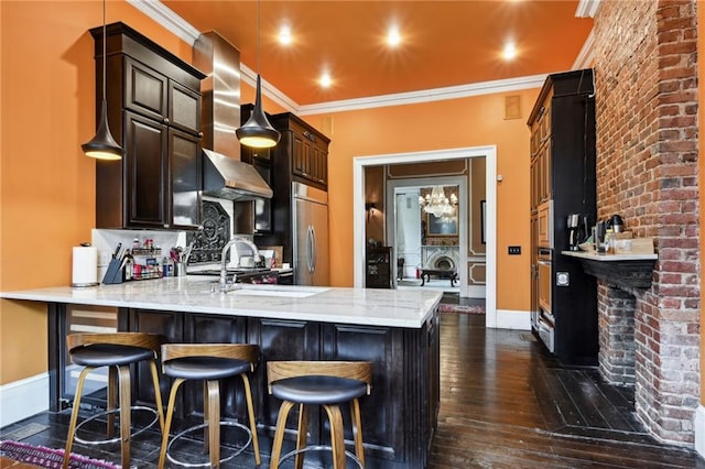 1555 N Miro St, New Orleans, LA 70119 - kitchen featuring a peninsula, appliances with stainless steel finishes, dark wood-type flooring, wall chimney exhaust hood, and light stone countertops