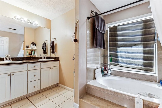 bathroom featuring vanity, tile patterned flooring, a textured ceiling, and a washtub