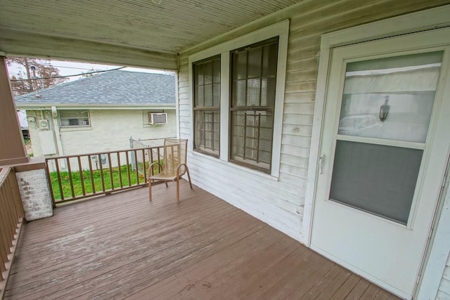 wooden deck featuring a porch and a wall mounted air conditioner