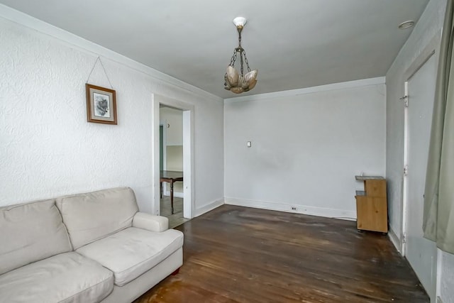 living room with crown molding, dark hardwood / wood-style floors, and a notable chandelier