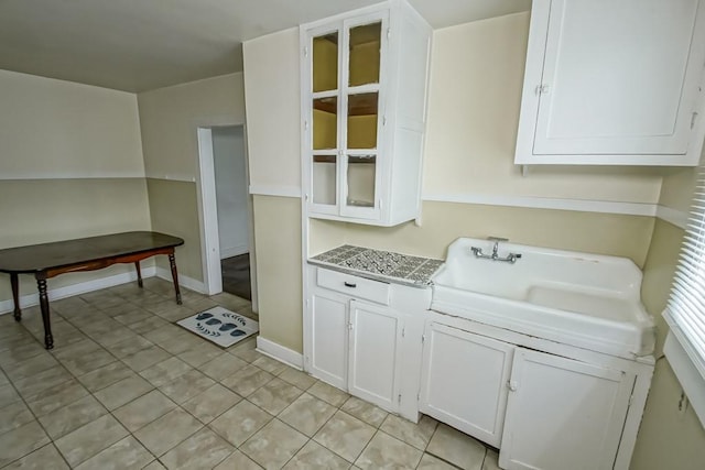 kitchen with white cabinetry, sink, and light tile patterned floors