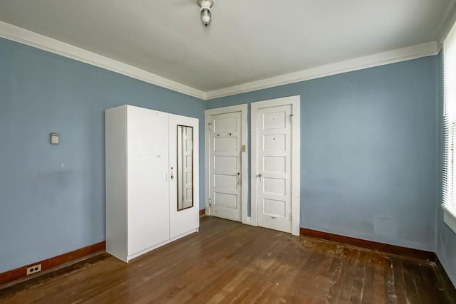 unfurnished bedroom featuring dark hardwood / wood-style flooring and crown molding