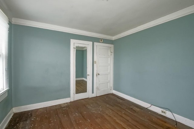 spare room with ornamental molding and dark hardwood / wood-style floors