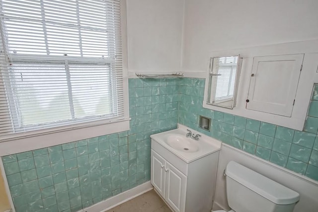 bathroom with vanity, toilet, and tile walls