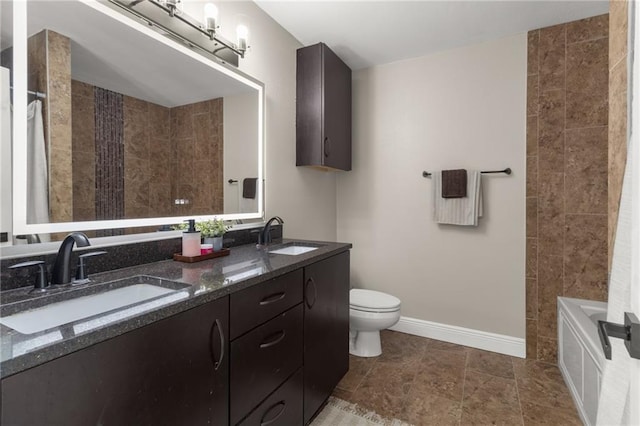 bathroom with vanity, a tub, and toilet