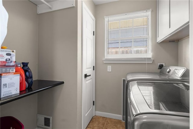 washroom with cabinets, washing machine and dryer, and light tile patterned floors