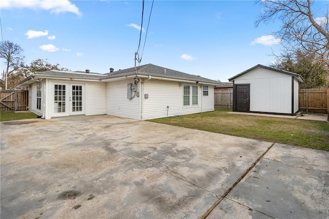 rear view of house featuring a storage shed, a patio area, french doors, and a lawn