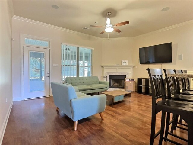 living room featuring crown molding, ceiling fan, and wood-type flooring