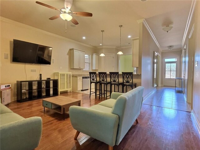 living room featuring crown molding, light hardwood / wood-style floors, and ceiling fan