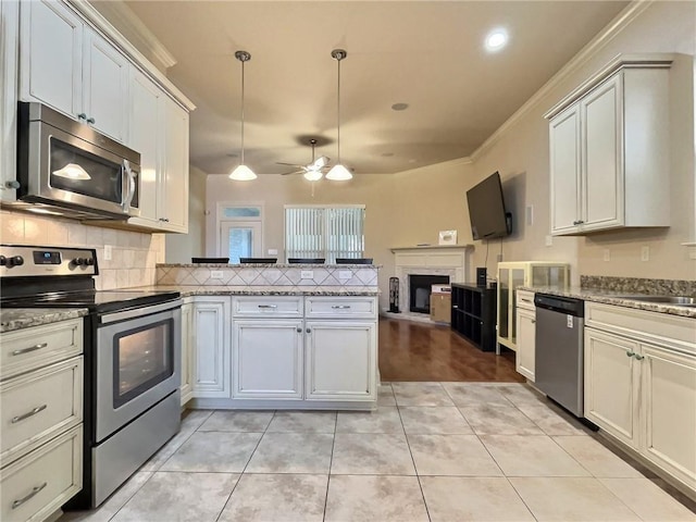 kitchen featuring light tile patterned floors, stainless steel appliances, open floor plan, backsplash, and decorative light fixtures