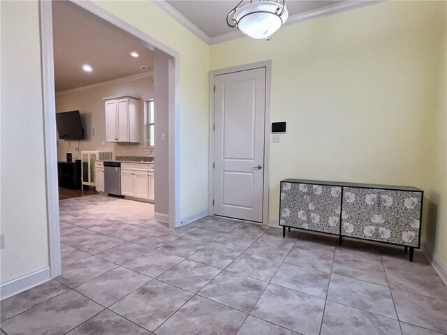 spare room featuring crown molding, baseboards, and light tile patterned floors