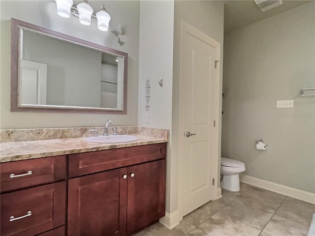 bathroom with a closet, toilet, vanity, tile patterned flooring, and baseboards