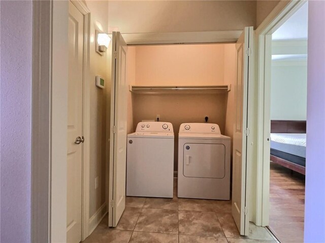 laundry room featuring laundry area, washing machine and dryer, and light tile patterned floors