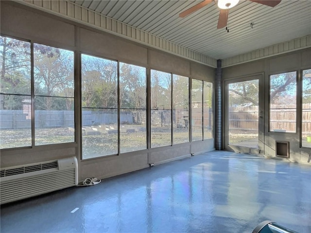 unfurnished sunroom featuring ceiling fan and a wall unit AC