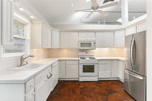 kitchen with sink, white appliances, ceiling fan, white cabinets, and vaulted ceiling