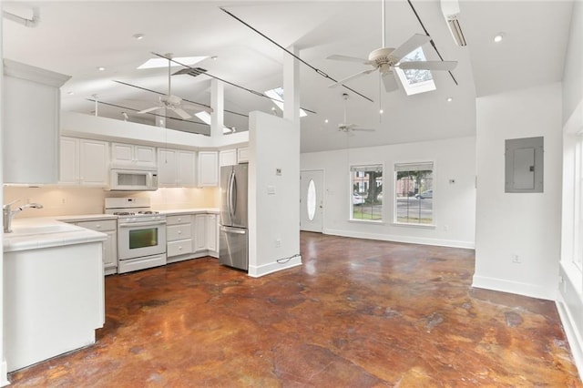 kitchen featuring sink, white appliances, ceiling fan, a skylight, and white cabinets