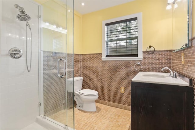 bathroom featuring toilet, an enclosed shower, tile walls, vanity, and tile patterned flooring