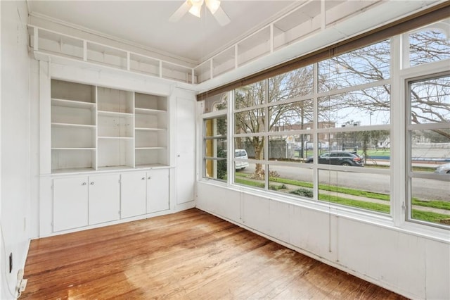 unfurnished sunroom featuring a wealth of natural light and ceiling fan