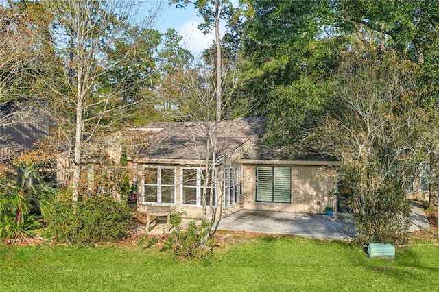 back of house with a patio area and a lawn