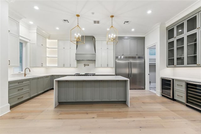 3705 Rue Emilion Dr, Metairie, LA 70002 - kitchen with appliances with stainless steel finishes, wine cooler, custom range hood, gray cabinets, and crown molding