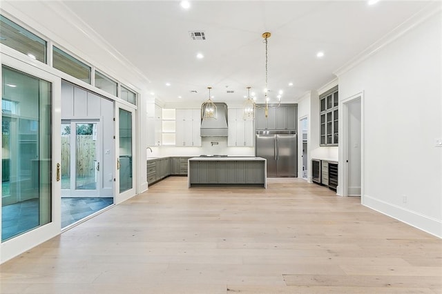 3705 Rue Emilion Dr, Metairie, LA 70002 - kitchen with stainless steel built in fridge, gray cabinetry, ornamental molding, recessed lighting, and premium range hood