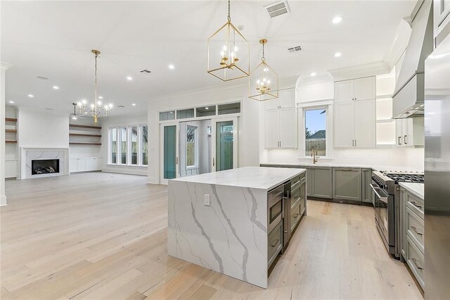 3705 Rue Emilion Dr, Metairie, LA 70002 - kitchen featuring stainless steel appliances, a chandelier, crown molding, a center island, and light wood-style floors