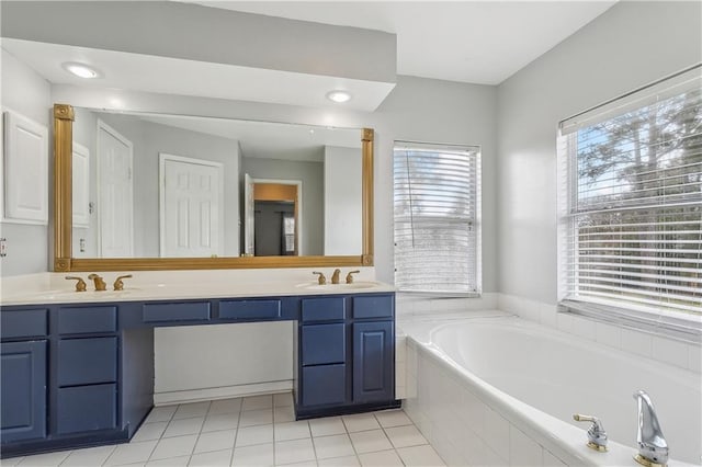 bathroom with tile patterned floors, vanity, and tiled tub