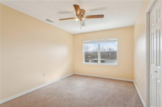 carpeted empty room with ceiling fan and a textured ceiling