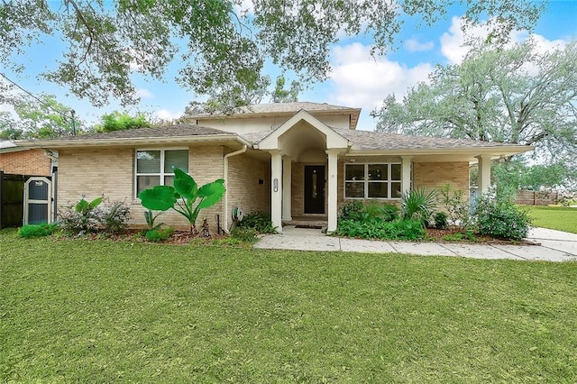 view of front of home with brick siding and a front lawn