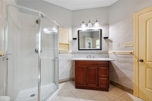 full bathroom with vanity, tile walls, a shower stall, and tile patterned flooring